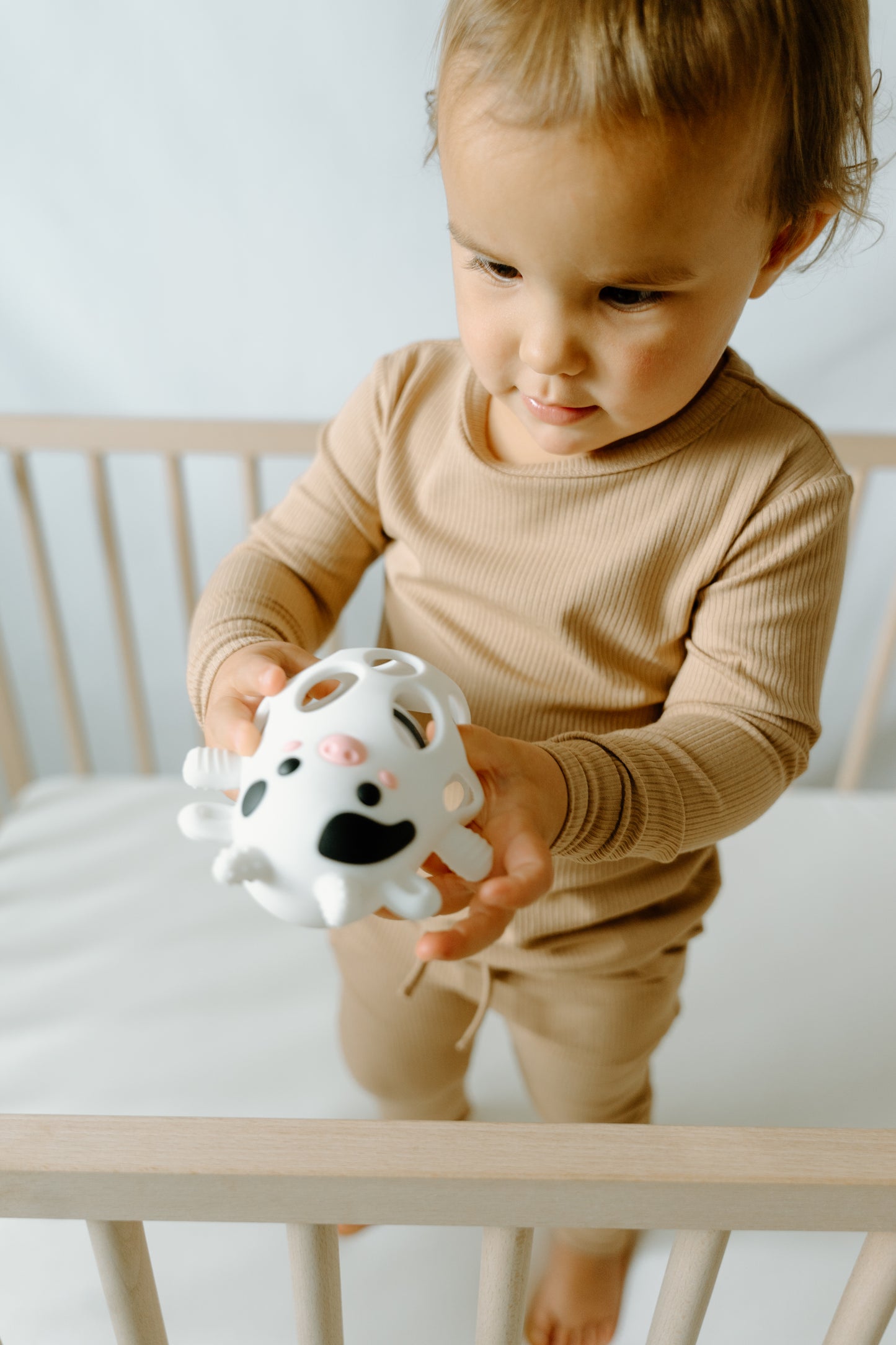 baby holding Millie the Cow silicone teether sensory toy
